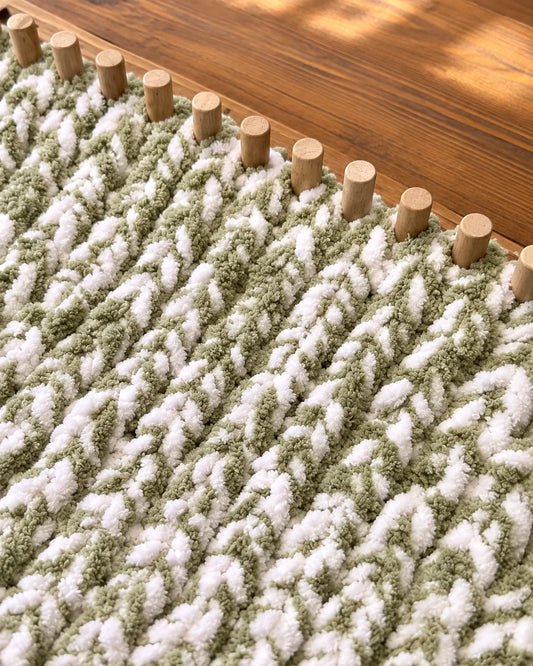 Sage and cream chunky chenille blanket in progress on wooden loom pegs